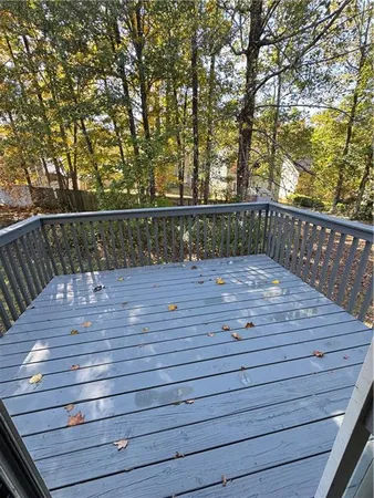 a view of deck with wooden floor and fence and trees