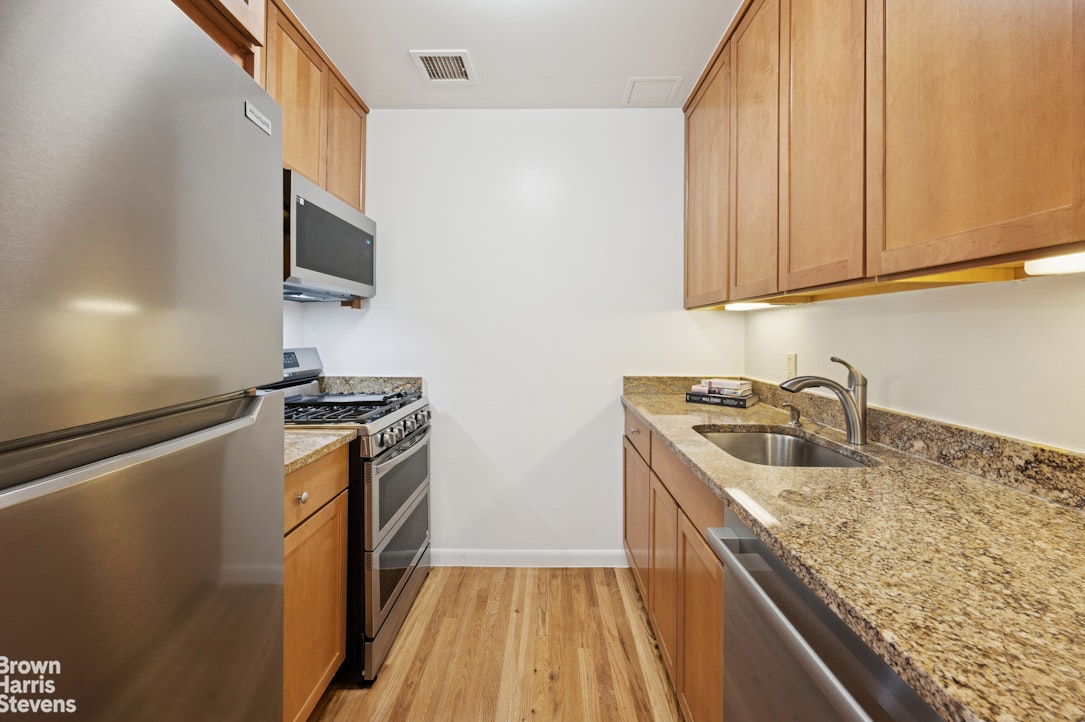 69 East 130th Street, Unit PHB Manhattan, NY 10037 - Photo 3 of 26 a kitchen with stainless steel appliances granite countertop a sink stove and refrigerator