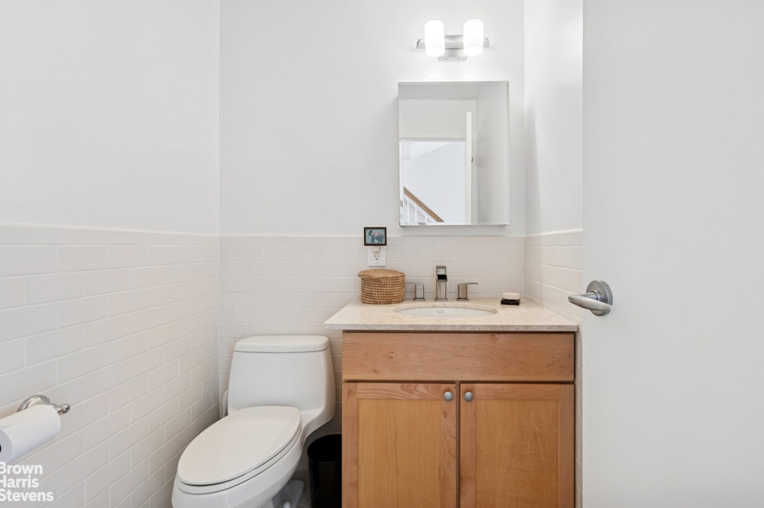 69 East 130th Street, Unit PHB Manhattan, NY 10037 - Photo 8 of 26 a bathroom with a toilet sink vanity and mirror