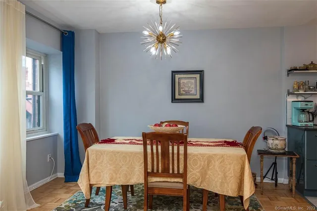 a kitchen with stainless steel appliances a stove a microwave a dining table and chairs