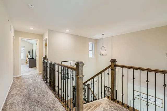 a view of a hallway with wooden floor and stairs