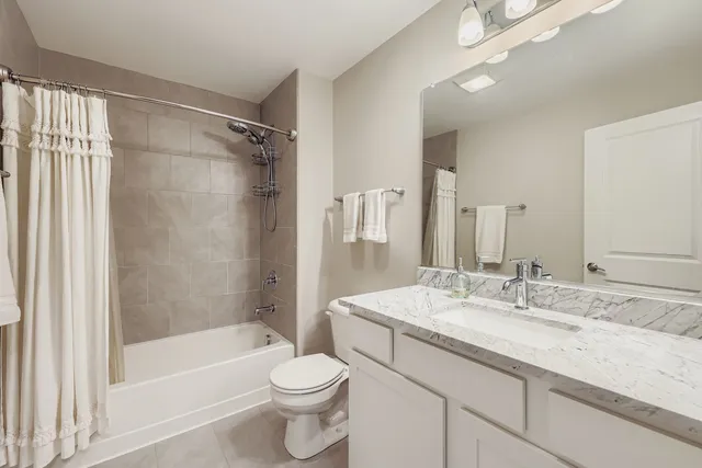 a bathroom with a granite countertop sink a toilet and shower