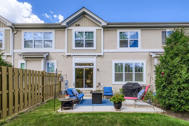 a view of a brick house with a chairs and table in a patio