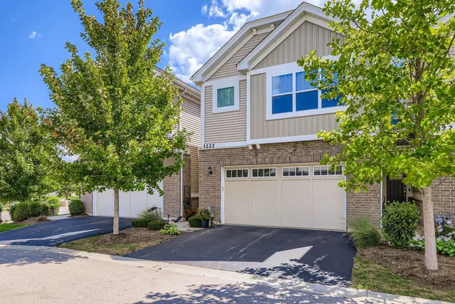 a front view of a house with a yard and trees