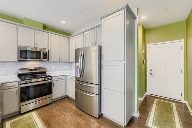 a kitchen with stainless steel appliances a refrigerator stove and microwave