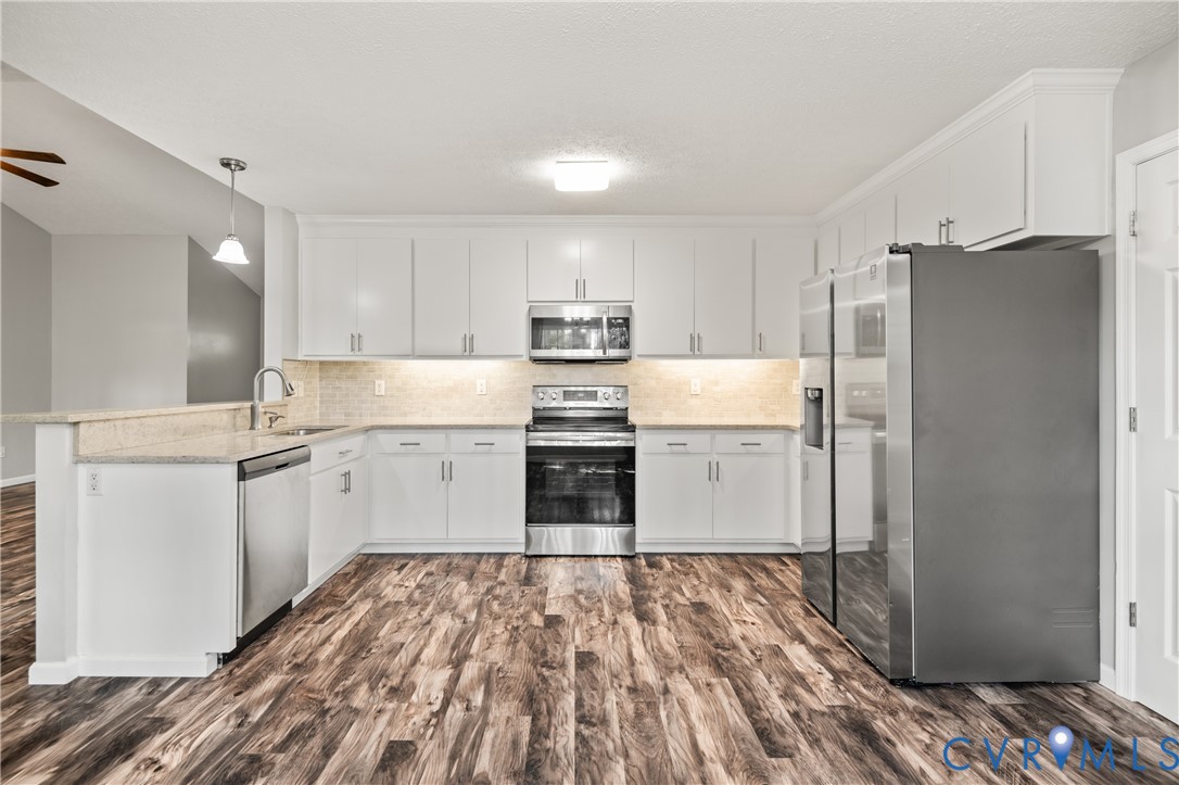 2099 Yacht Club Road Hayes, VA 23072 - Photo 15 of 42 a kitchen with granite countertop white cabinets and refrigerator