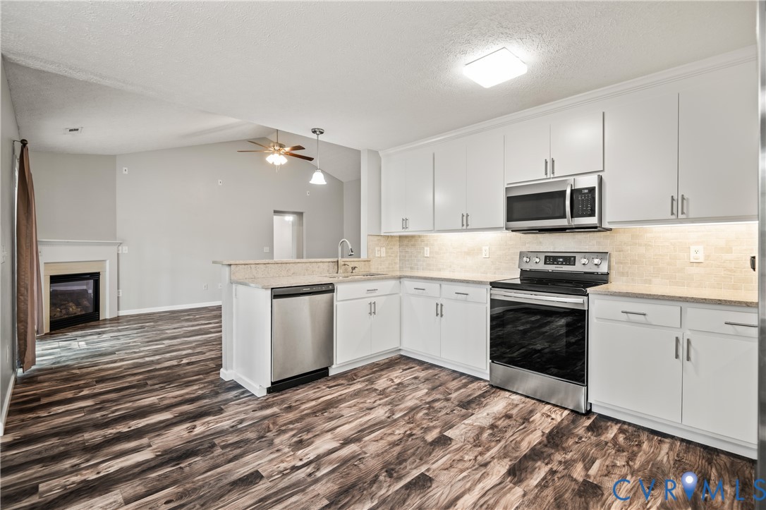 2099 Yacht Club Road Hayes, VA 23072 - Photo 16 of 42 a kitchen with granite countertop a stove top oven and cabinets