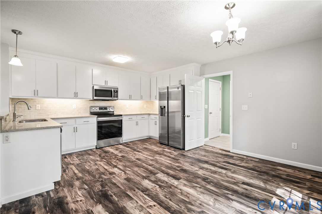 2099 Yacht Club Road Hayes, VA 23072 - Photo 21 of 42 a kitchen with stainless steel appliances granite countertop a refrigerator sink and stove