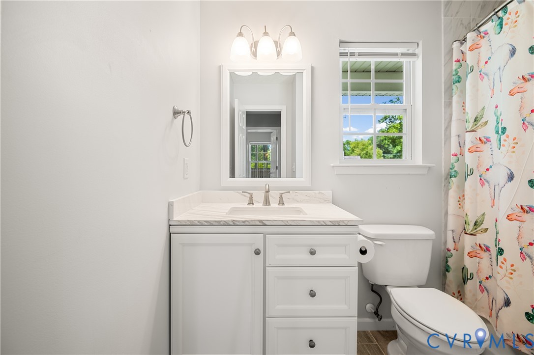 2099 Yacht Club Road Hayes, VA 23072 - Photo 34 of 42 a bathroom with a granite countertop toilet sink and mirror