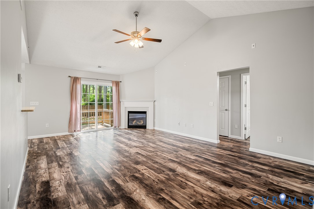 2099 Yacht Club Road Hayes, VA 23072 - Photo 8 of 42 an empty room with wooden floor fireplace and windows
