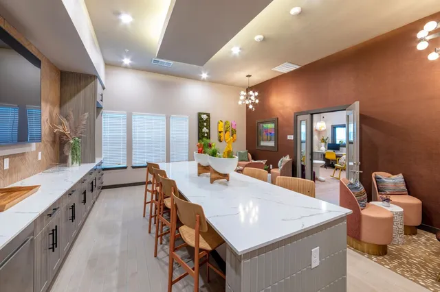 a dining hall with stainless steel appliances granite countertop a sink and dishwasher a stove with wooden floor