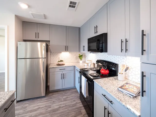 a kitchen with stainless steel appliances a stove refrigerator and microwave