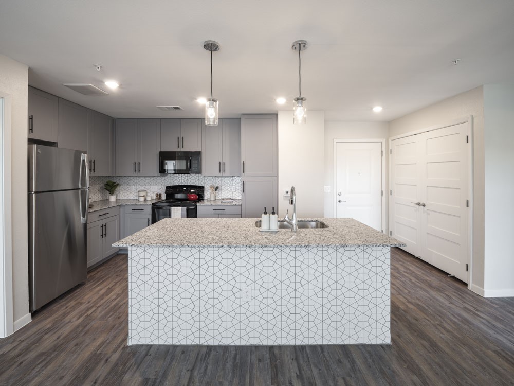 4611 North Interstate 35 Frontage Road Austin, TX 78722 - Photo 7 of 11 a large kitchen with stainless steel appliances granite countertop a stove a refrigerator a oven and a wooden floors