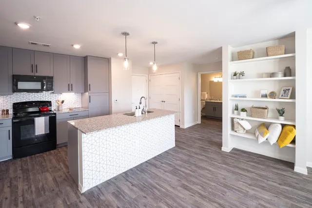 a large kitchen with kitchen island a stove a sink a refrigerator and a cabinets