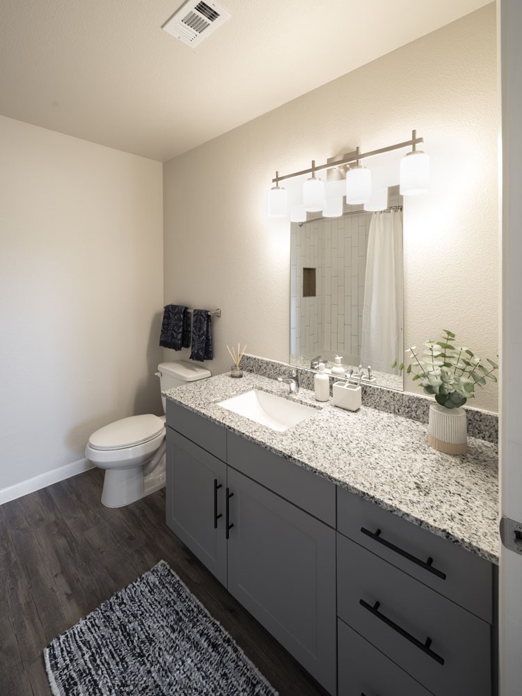 4611 North Interstate 35 Frontage Road Austin, TX 78722 - Photo 10 of 11 a bathroom with a granite countertop toilet a sink and a mirror