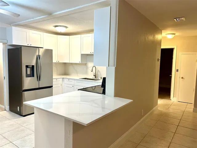 a kitchen with stainless steel appliances a refrigerator and a counter space