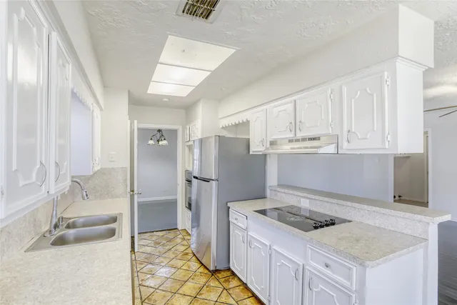 a kitchen with a stove a refrigerator and cabinets