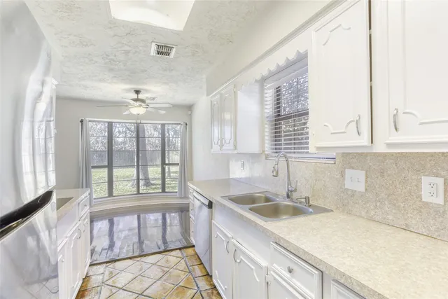a kitchen that has a sink a stove and a microwave oven in it