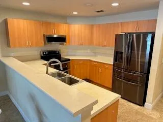 a kitchen with stainless steel appliances granite countertop a refrigerator a sink a stove a microwave and island