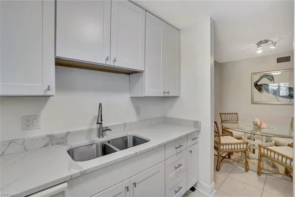 a kitchen with white cabinets and a sink