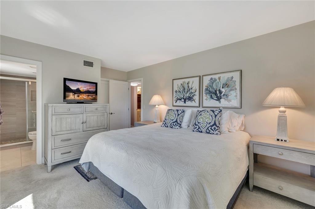 766 Central Avenue, Unit 304 Naples, FL 34102 - Photo 17 of 29 a bedroom with a bed and a flat screen tv