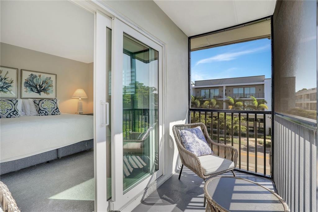 766 Central Avenue, Unit 304 Naples, FL 34102 - Photo 19 of 29 a bedroom with a bed and glass door