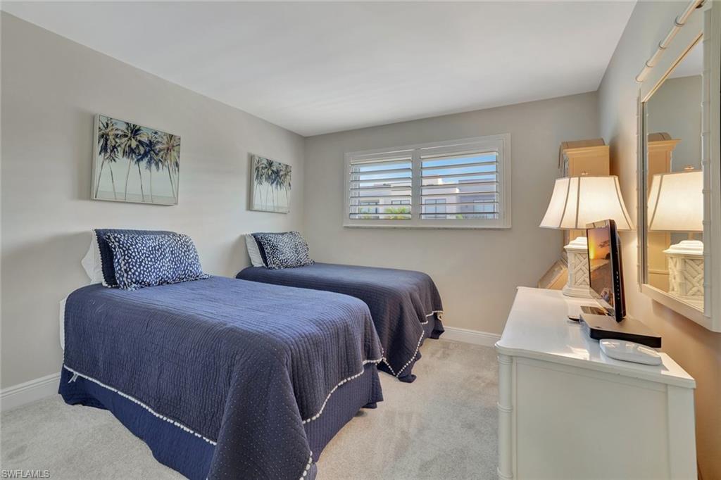 766 Central Avenue, Unit 304 Naples, FL 34102 - Photo 20 of 29 a spacious bedroom with a bed and window