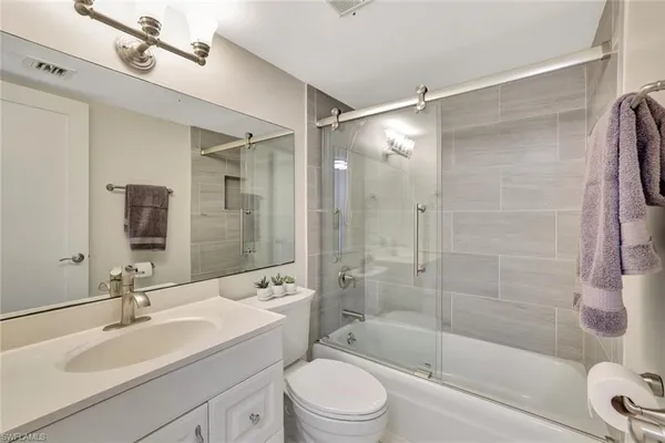a bathroom with a sink mirror bathtub and toilet