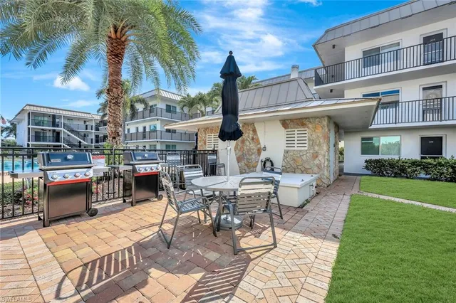 a view of a patio with couches table and chairs and potted plants