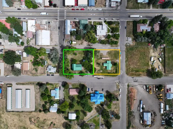 an aerial view of a house with a yard and a large tree