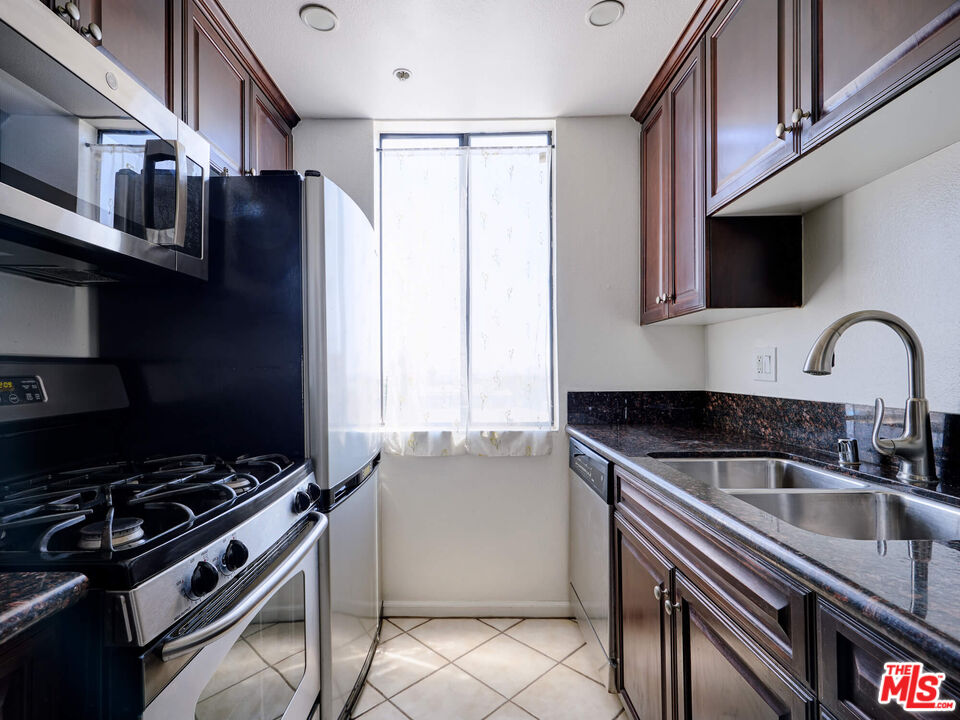 7320 Hawthorn Avenue, Unit 222 Los Angeles, CA 90046 - Photo 11 of 33 a kitchen with granite countertop a stove and a sink