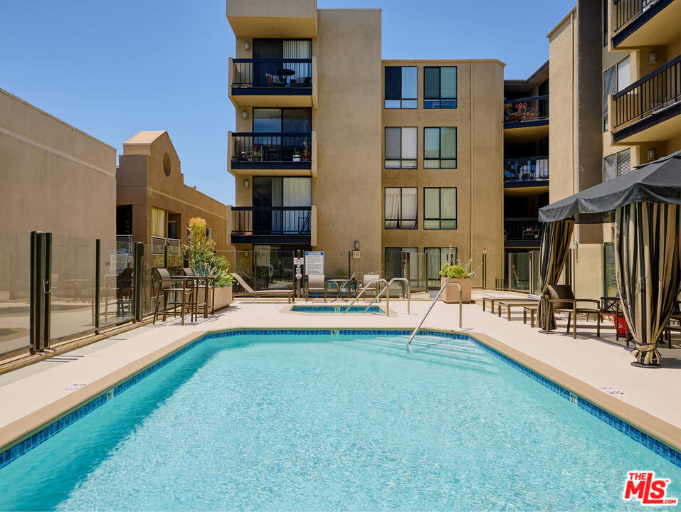 7320 Hawthorn Avenue, Unit 222 Los Angeles, CA 90046 - Photo 28 of 33 a swimming pool with outdoor seating and a garden