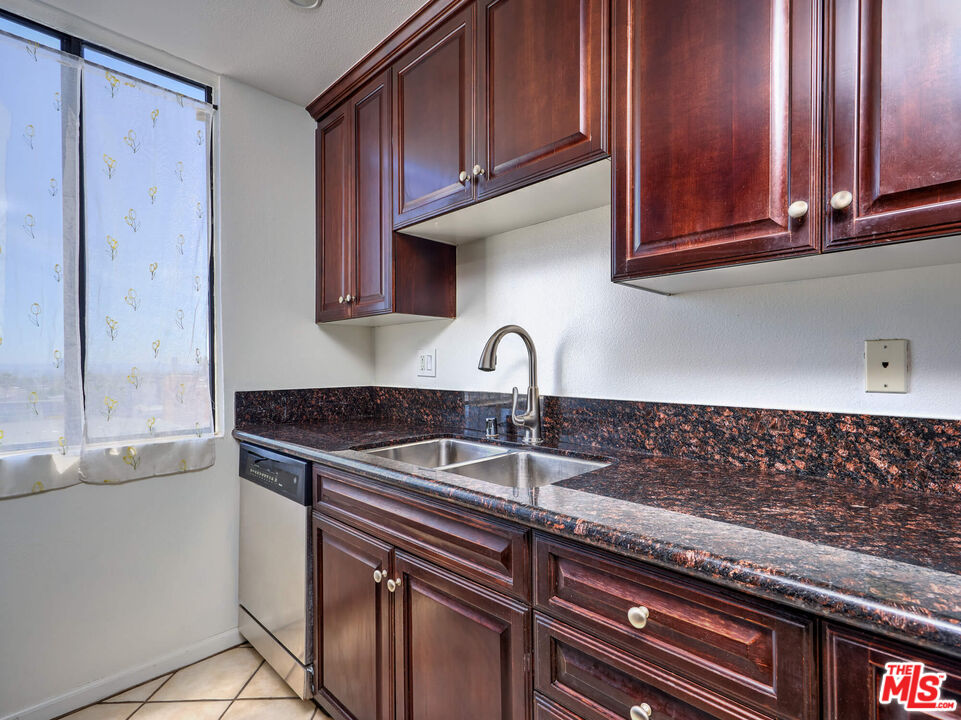 7320 Hawthorn Avenue, Unit 222 Los Angeles, CA 90046 - Photo 10 of 33 a kitchen with granite countertop stainless steel appliances wooden cabinet and a sink