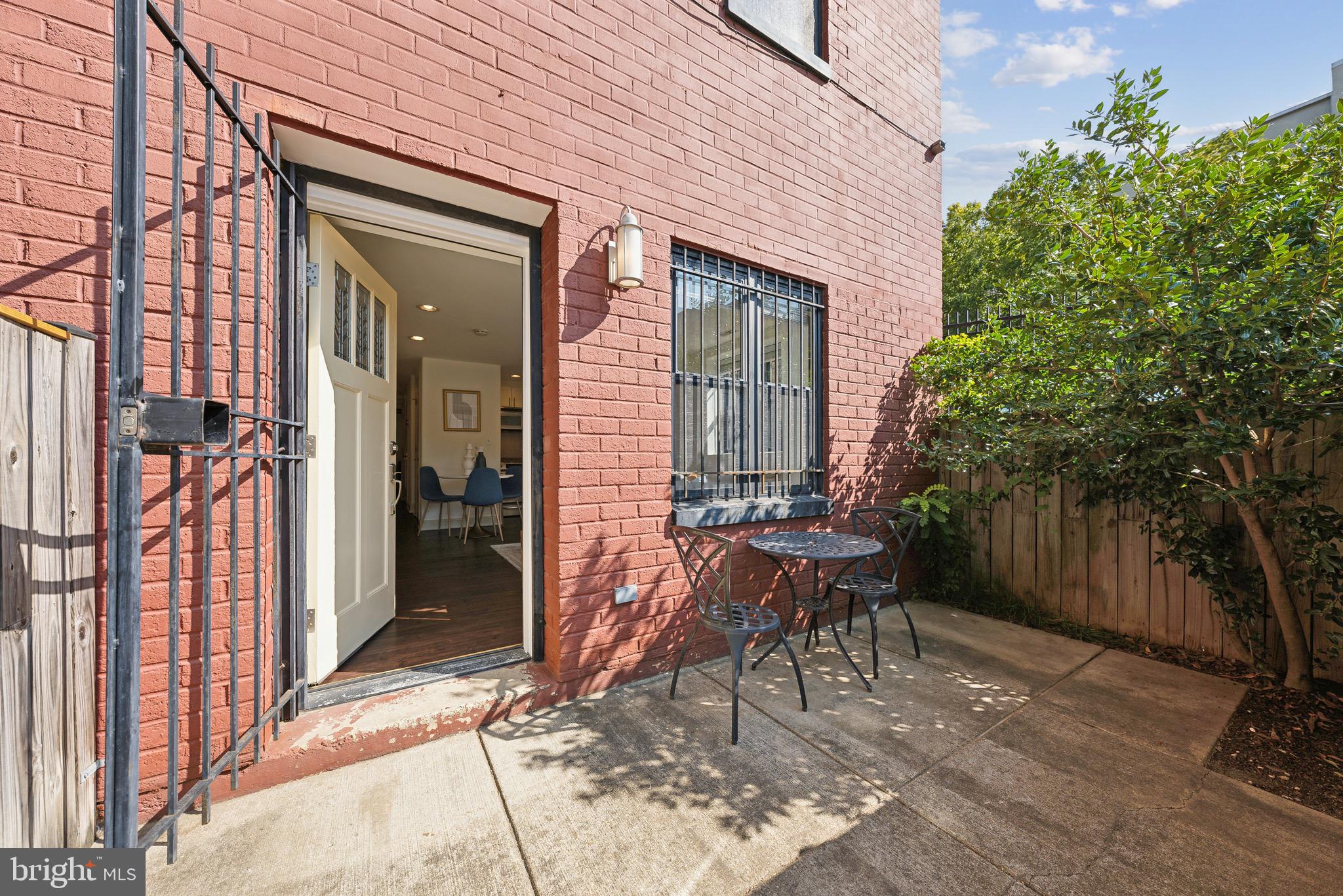 1354 Euclid Street Northwest, Unit 101B Washington, DC 20009 - Photo 1 of 15 a view of a patio with table and chairs and potted plants