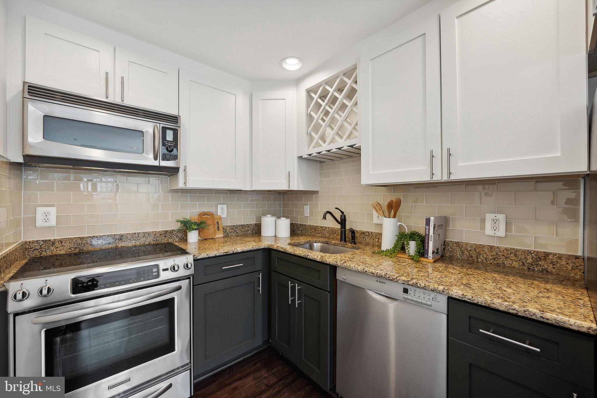 1354 Euclid Street Northwest, Unit 101B Washington, DC 20009 - Photo 7 of 15 a kitchen with stainless steel appliances granite countertop a sink a stove and microwave