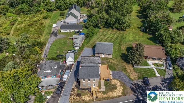 an aerial view of a house with garden space and street view
