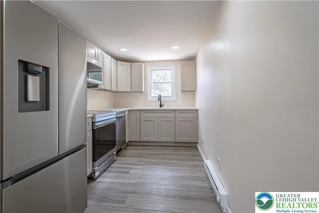 a kitchen with a sink a window and stainless steel appliances