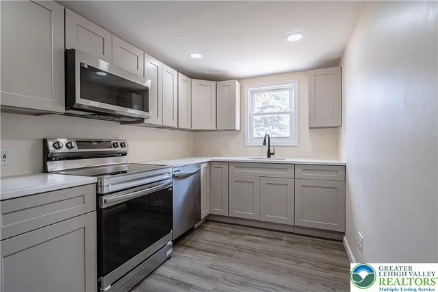 a kitchen with stainless steel appliances granite countertop a sink a stove a microwave and cabinets