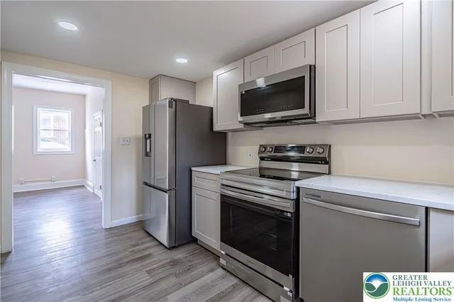 a kitchen with stainless steel appliances a stove a microwave and sink