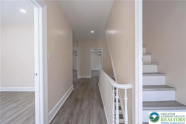 a view of a hallway with wooden floor and staircase