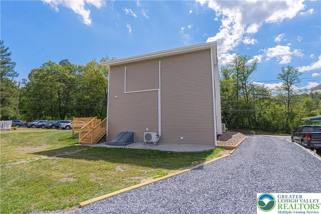 a view of a backyard with potted plants and large trees