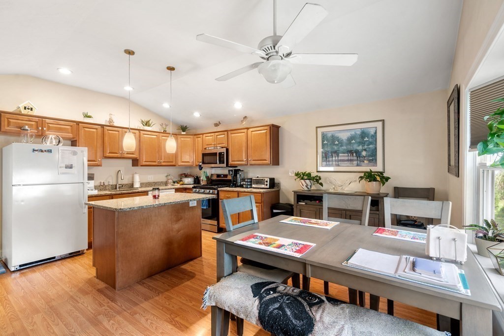 16 Monack Road Wareham, MA 02532 - Photo 6 of 24 a open kitchen with stainless steel appliances kitchen island granite countertop a refrigerator a stove a sink dishwasher and white countertops with wooden floor