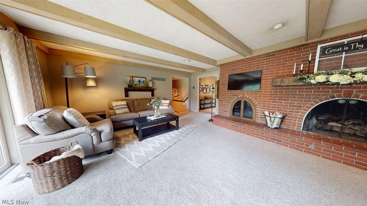 3985 Wiers Road Willard, OH 44890 - Photo 19 of 50 Exposed ceiling beams define this living area featuring a prominent brick fireplace with a wood mantel