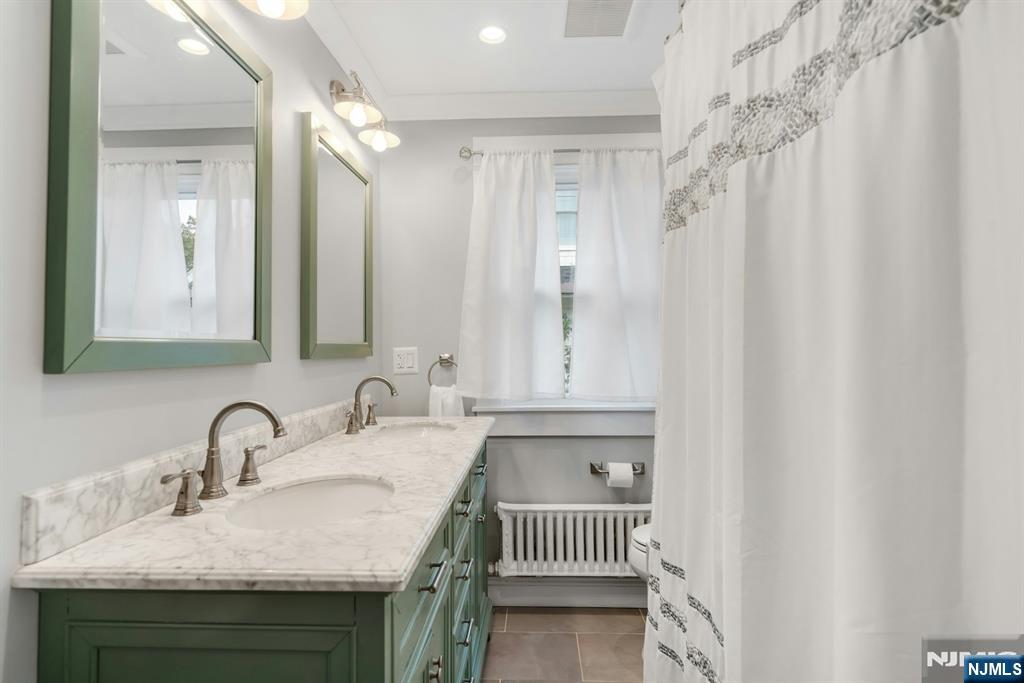 409 Warren Avenue Ho-Ho-Kus, NJ 07423 - Photo 14 of 23 a bathroom with a sink and a mirror