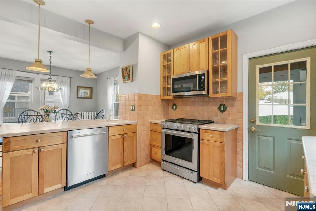 409 Warren Avenue Ho-Ho-Kus, NJ 07423 - Photo 9 of 23 a kitchen with stainless steel appliances granite countertop a stove a sink and a microwave