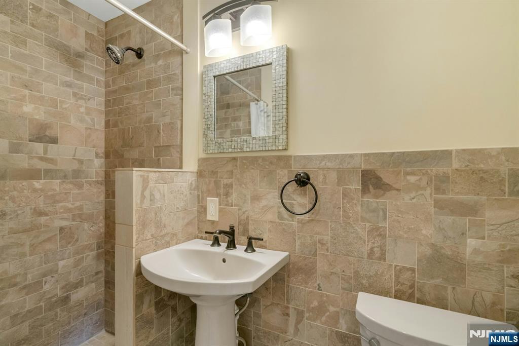 409 Warren Avenue Ho-Ho-Kus, NJ 07423 - Photo 10 of 23 a bathroom with a sink toilet and shower