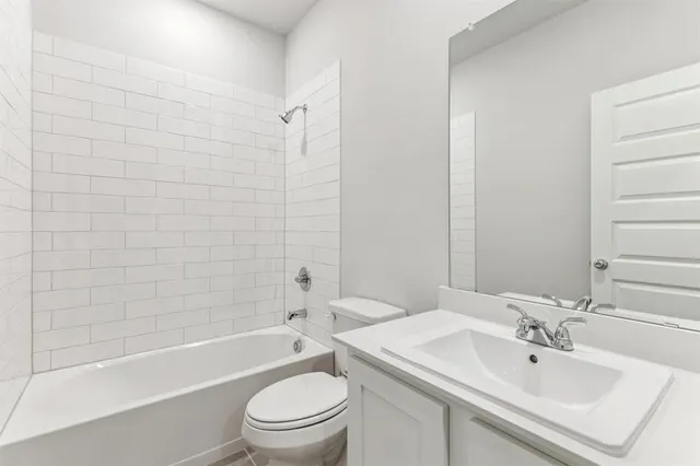 a bathroom with a bathtub shower sink vanity and toilet