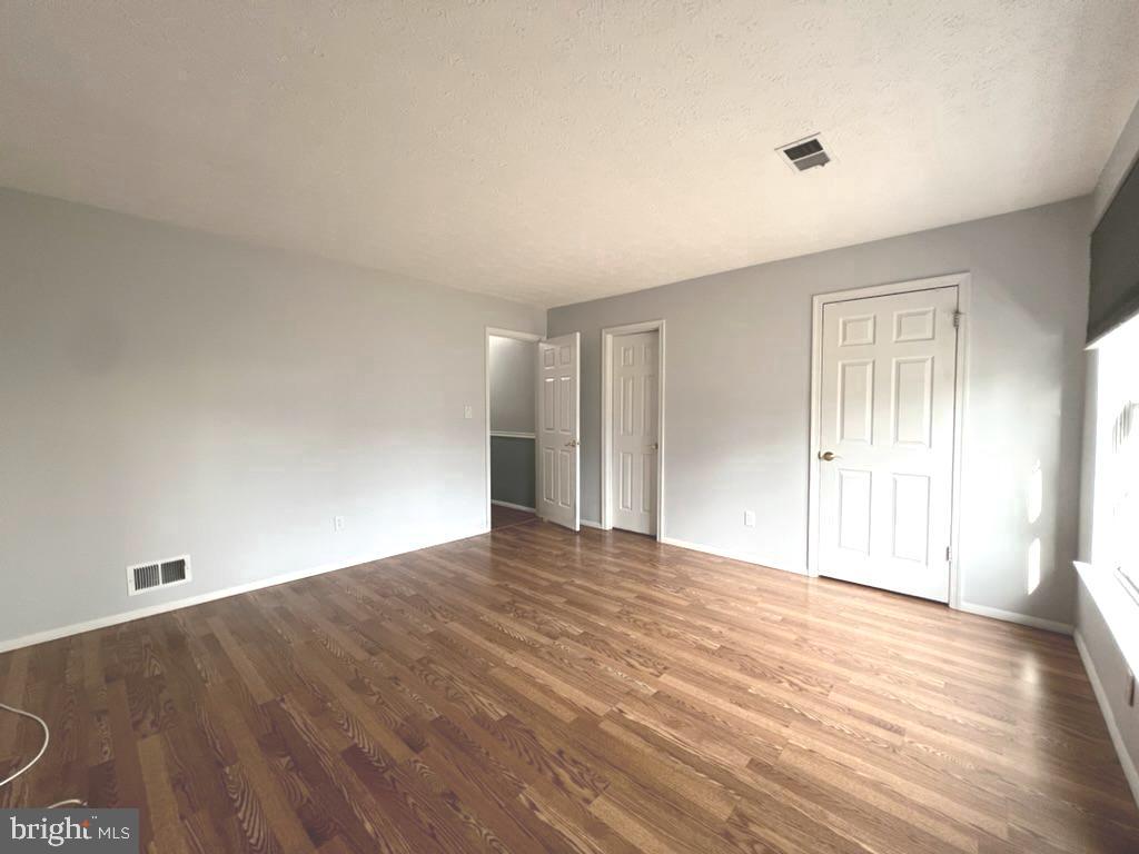 8220 Grainfield Road Severn, MD 21144 - Photo 11 of 23 a view of an empty room with wooden floor and a window