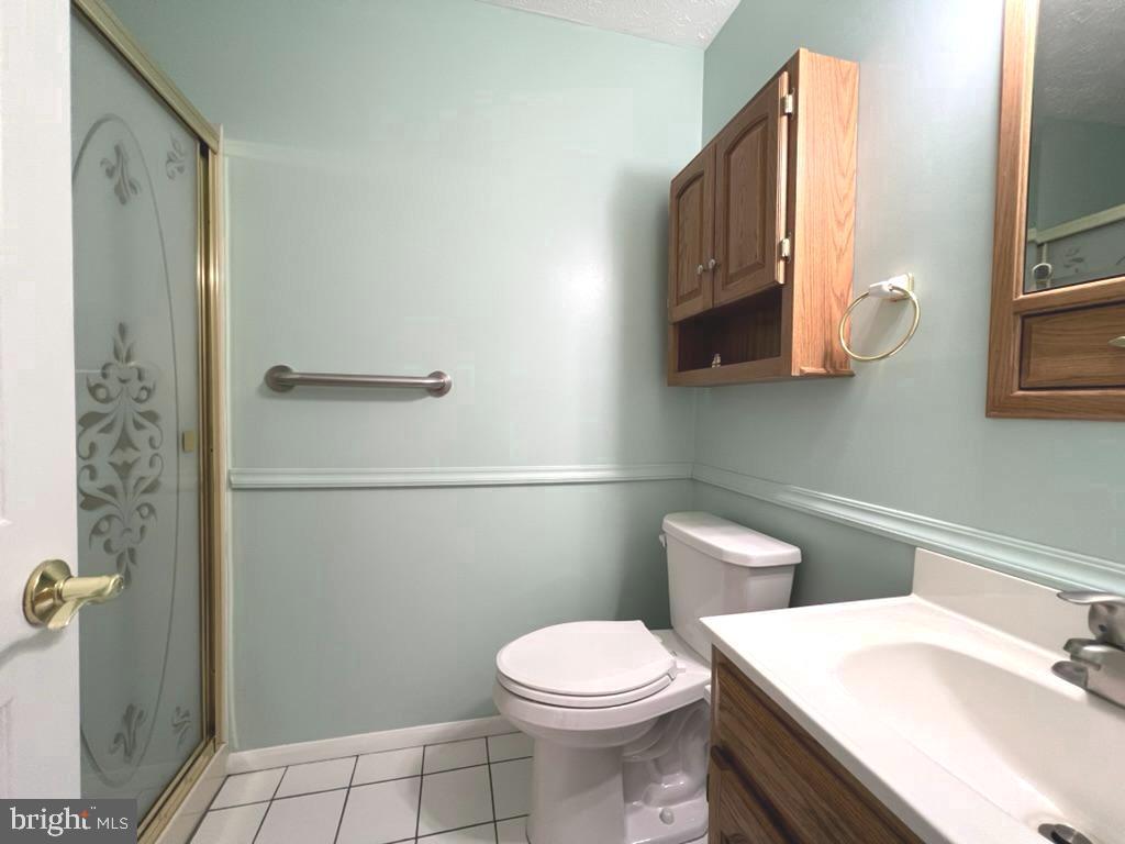 8220 Grainfield Road Severn, MD 21144 - Photo 12 of 23 a white toilet sitting next to a bathroom sink