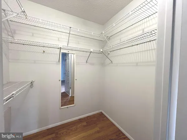 a view of a room with wooden floor and fan